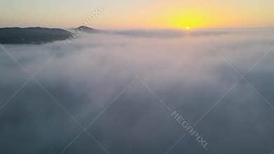 Descending flight from sunrise above clouds