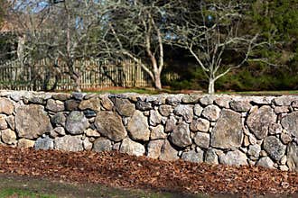 A carefully built stone wall borders the side of a road in Westport MA