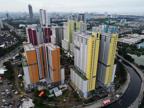 Aerial drone view of modern apartment building in Jakarta central business district with Jakarta cityscape and noise cloud.