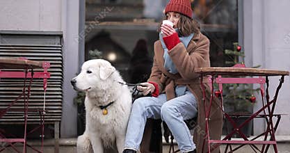 Woman with her dog at the cafe in winter