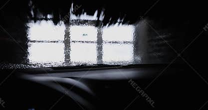 Automatic car wash brushes washing windshield. inside view