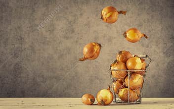 A metal basket with lots of onions