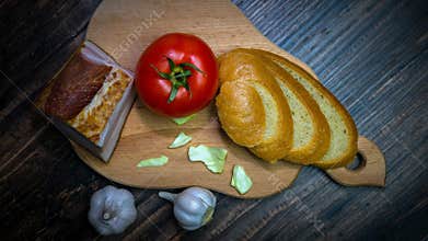 Food on a wooden tray, ham with vegetables, still life of food, tomato garlic with lard top view.