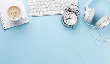 Office desk with supplies alarm clock and coffee