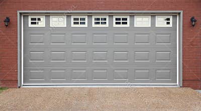 Garage with doors, brick wall and asphalt driveway