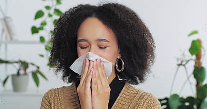 Portrait of afro american woman girl teenager suffering from allergy symptoms wipes nose with white paper napkin with