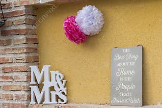 Closeup of the pom poms flower decoration with the word \"Mr &Mrs\" on the wall