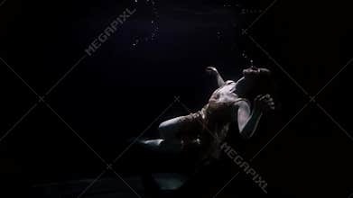 sunken woman is downing on bottom of sea or river, underwater shot of female figure in darkness and deepness