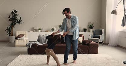 Happy energetic young father playing with small son.