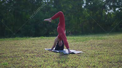 Orbiting slow motion Asian chinese female yoga yogi stretching in morning sun singapore