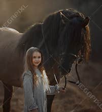 Long haired Little girl  in casual style with brown horse