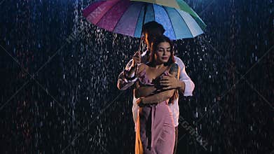 Love story of couple in rain, expressed in passionate dance. Romantic meeting of two lovers. Couple under bright colored
