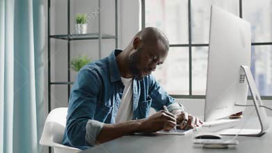 Black freelancer with crew cut draws template on new tablet