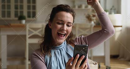 Sincere young pretty woman celebrating online lottery win.