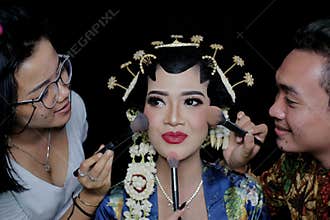 A Sinden, an artist who specializes in singing traditional Javanese songs, conducts a photo session with make-up artists
