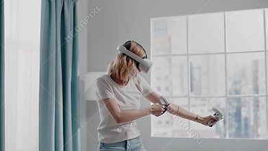 Concentrated woman charges bow playing game with VR headset