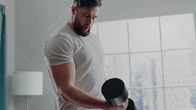 Active sportsman with beard practices dumbbell biceps curl