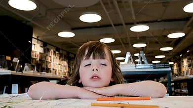 Thoughtful brunette girl with hair bangs in large bookstore
