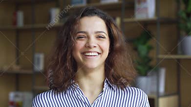 Cheerful happy hispanic young adult 20s woman looking at camera, headshot.
