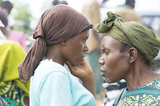 Thoughtful African women with scarf bounded hair accessories on street market in Uganda