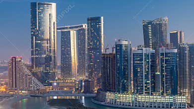 Buildings on Al Reem island in Abu Dhabi day to night from above.