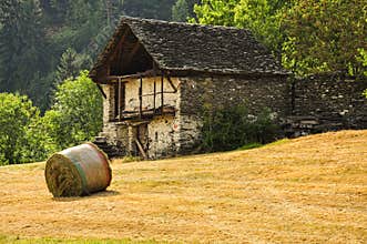 Old stone house and meadow in the Italian Alps