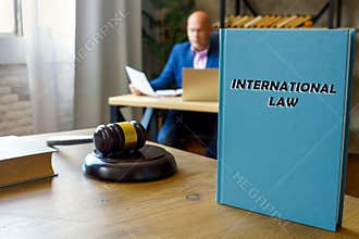 Lawyer holds INTERNATIONAL LAW book. TheÂ international lawÂ is enshrined in conventions, treaties and standards