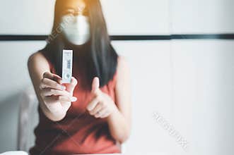 Patient woman showing result a covid-19 self test rapid antigen testing kit at home