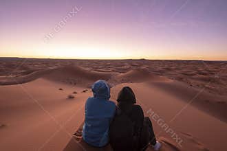 Night landscape with loving couple in the desert near Merzouga, Morocco