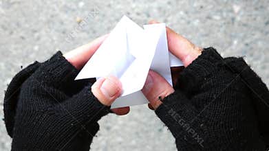 Homeless person creating Origami home