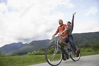 Cheerful Middle aged Couple Bicycling On Country Road