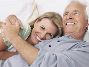 Middle Aged Couple Embracing In Bed