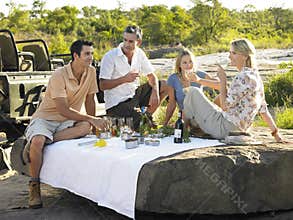 People Enjoying Picnic On Rock