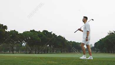 Man with club walking along spring sports field portrait