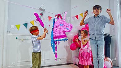 Little blindfolded boy enjoys a playful pinata party adventure