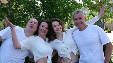 Happy casual hispanic family posing outside. European appearance curly hair beautiful faces latin parents and children