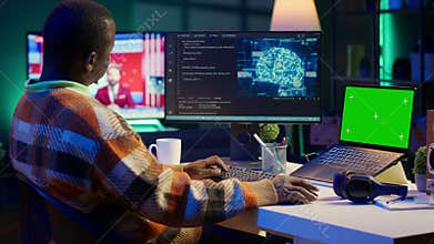 African american man using AI to develop a software system with chroma key on pc