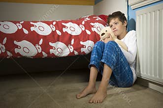 Sad and depressed boy on bedroom
