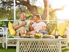 Two seniors having dinner on patio.