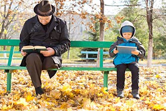 Elderly man and small boy sharing a park bench