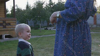 Little boy rubbing his pregnant mom's belly outdoor