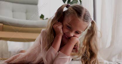 Happy girl lying and leaning head on hands