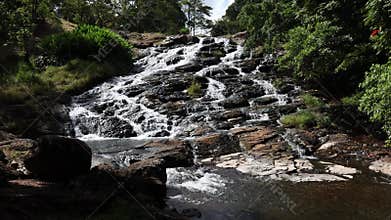A stream cascading over a rock formation to the pool below