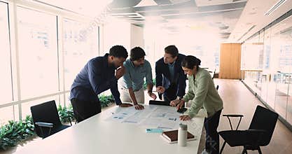 Diverse businesspeople discuss financial report in charts and diagrams