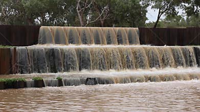 Water spilling over a weir in three steps in outback Australia.