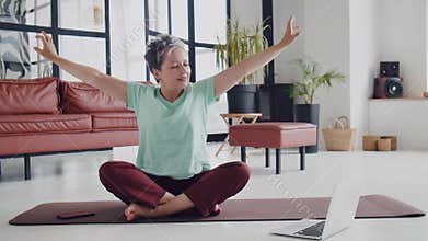 Old woman make yoga exercise at home. Mature woman preparing to exercise by warm up muscle, neck, hands, head