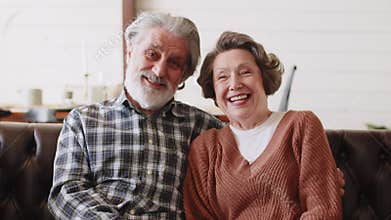 Senior couple sitting on the coach and talking together with happiness. Healthy elderly husband and wife relax and enjoy