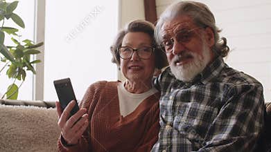 Elderly grandparents having fun with smartphone apps, middle-aged wife enjoying online entertainment