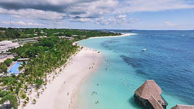 Aerial view of bungalow, white sandy beach, sea and palms