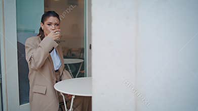 Relaxed woman drinking coffee in small urban cafeteria. Calm girl sitting cafe